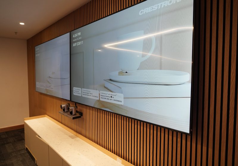 Dual displays and camera system installed on a boardroom wall.