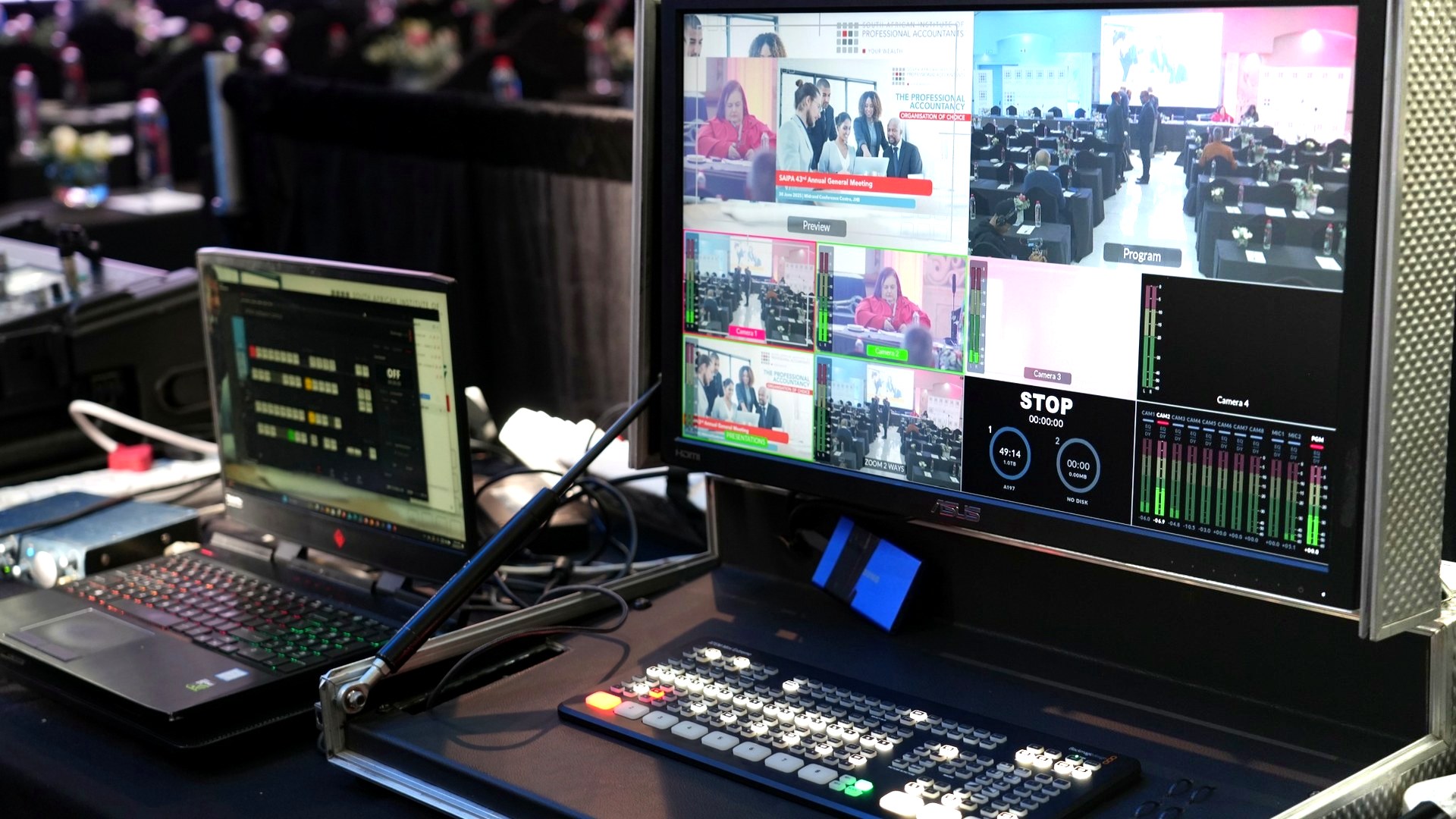 Streaming control desk with multiview monitor and event production background.