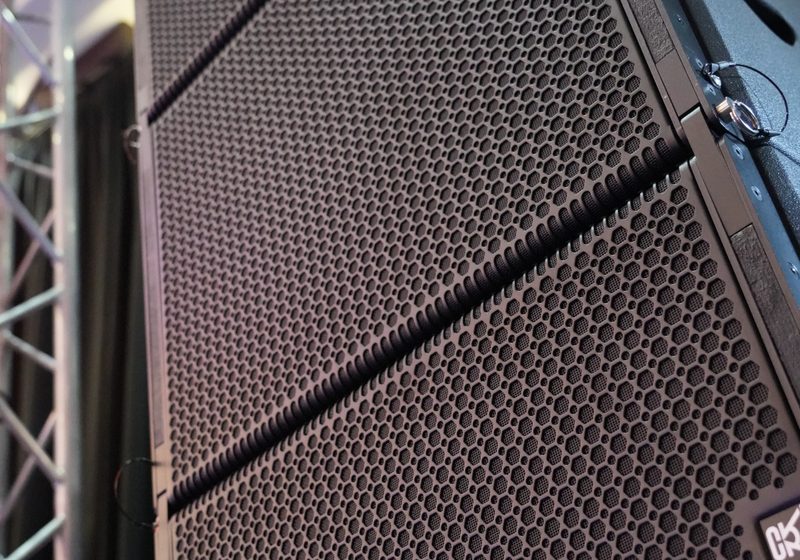 Close-up of stacked professional speaker array next to truss.