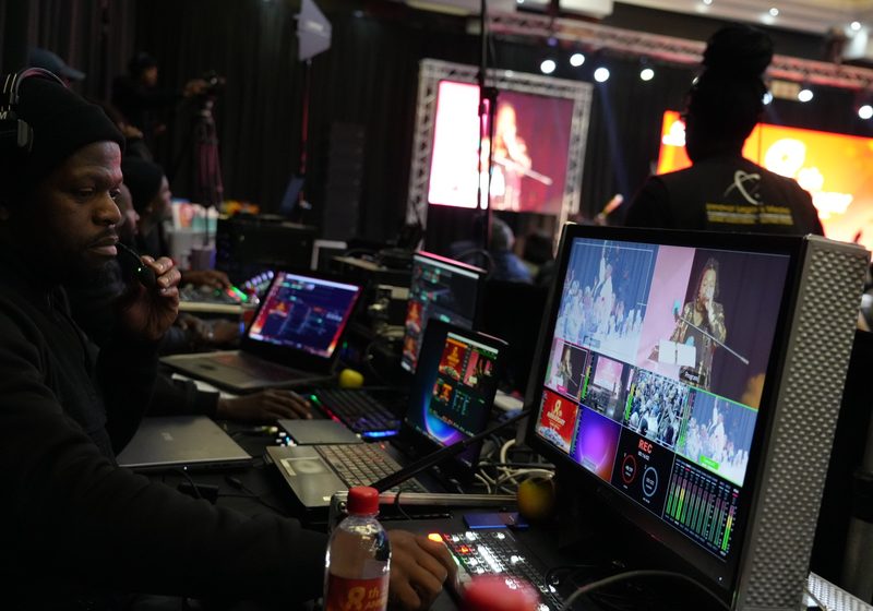 Operator at live technical control desk with multiview and event feed monitors.