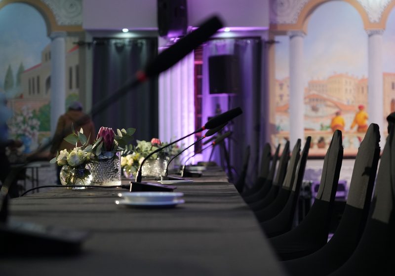 Formal venue conference table with microphones and event-ready room setup.