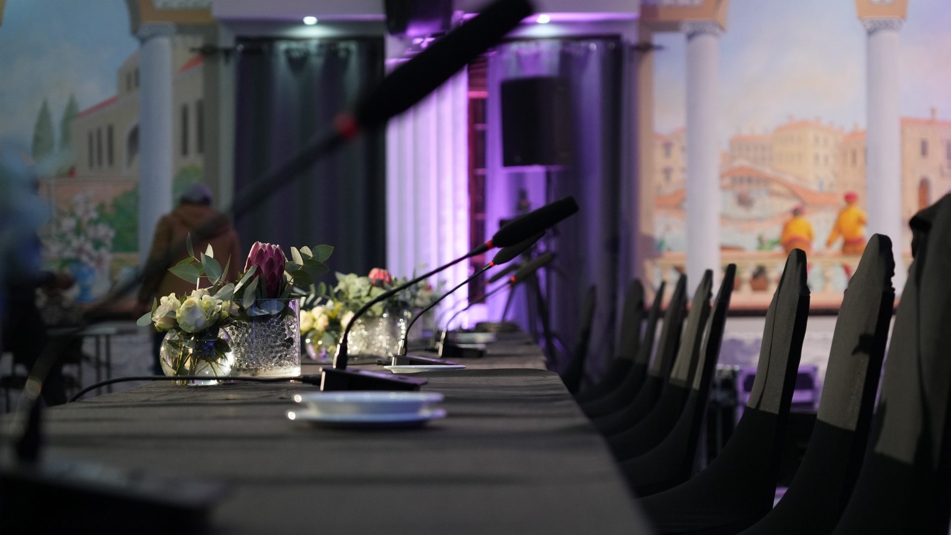 Formal venue conference table with microphones and event-ready room setup.