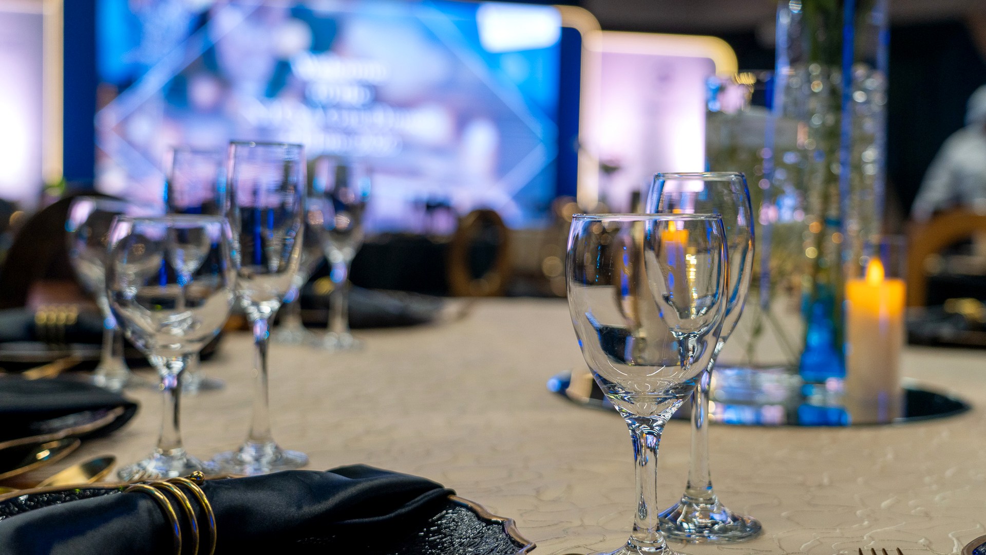 Wide event venue with stage, LED, podium, seating and AV readiness.