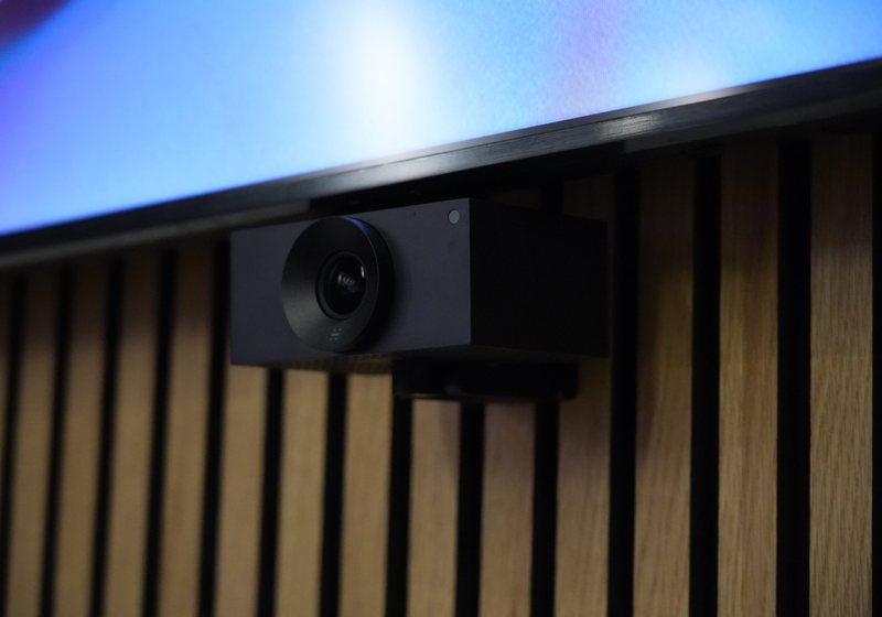 Conferencing camera mounted below a display on a timber slat wall