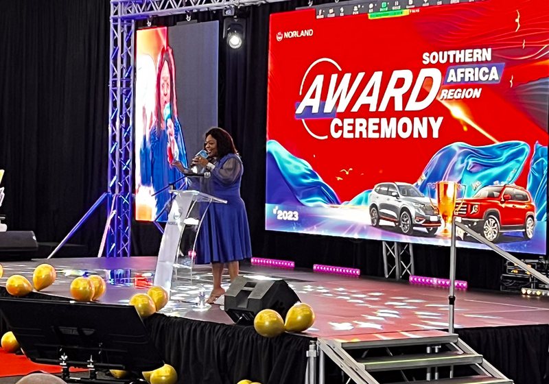 Awards stage with a main LED screen and two side screens showing the speaker
